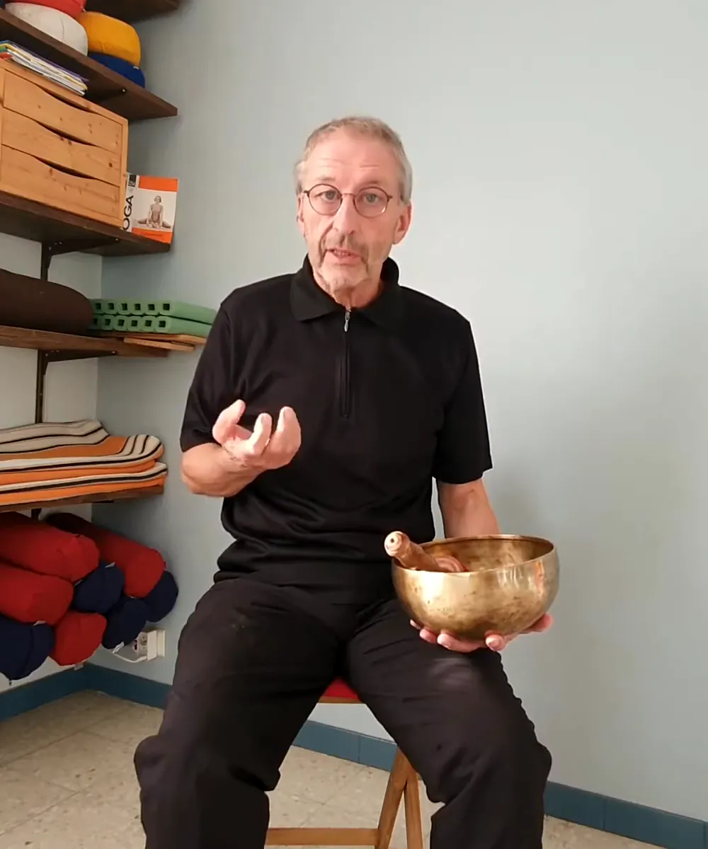 Jean-Louis Sitjar assis, qui explique en tenant un bol tibétain