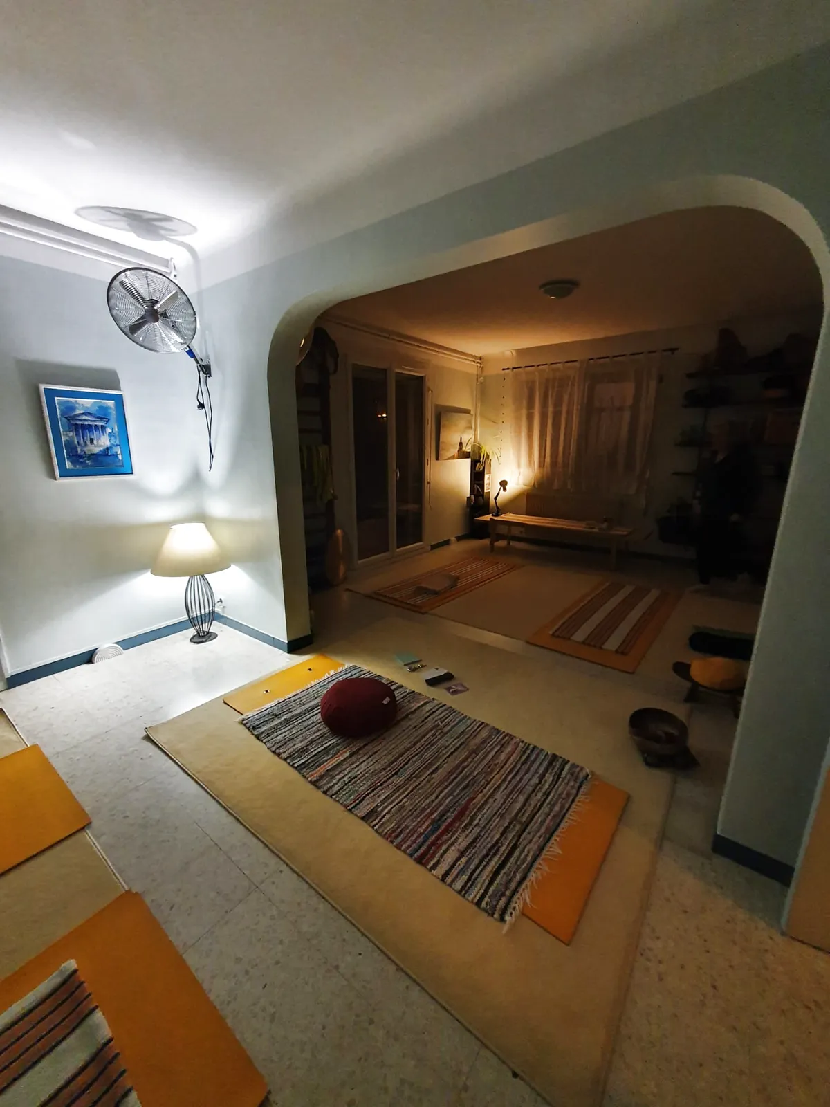 La salle de yoga de Bouillargues le soir : tapis tissés, coussin de méditation, bol tibétain, lumière douce
